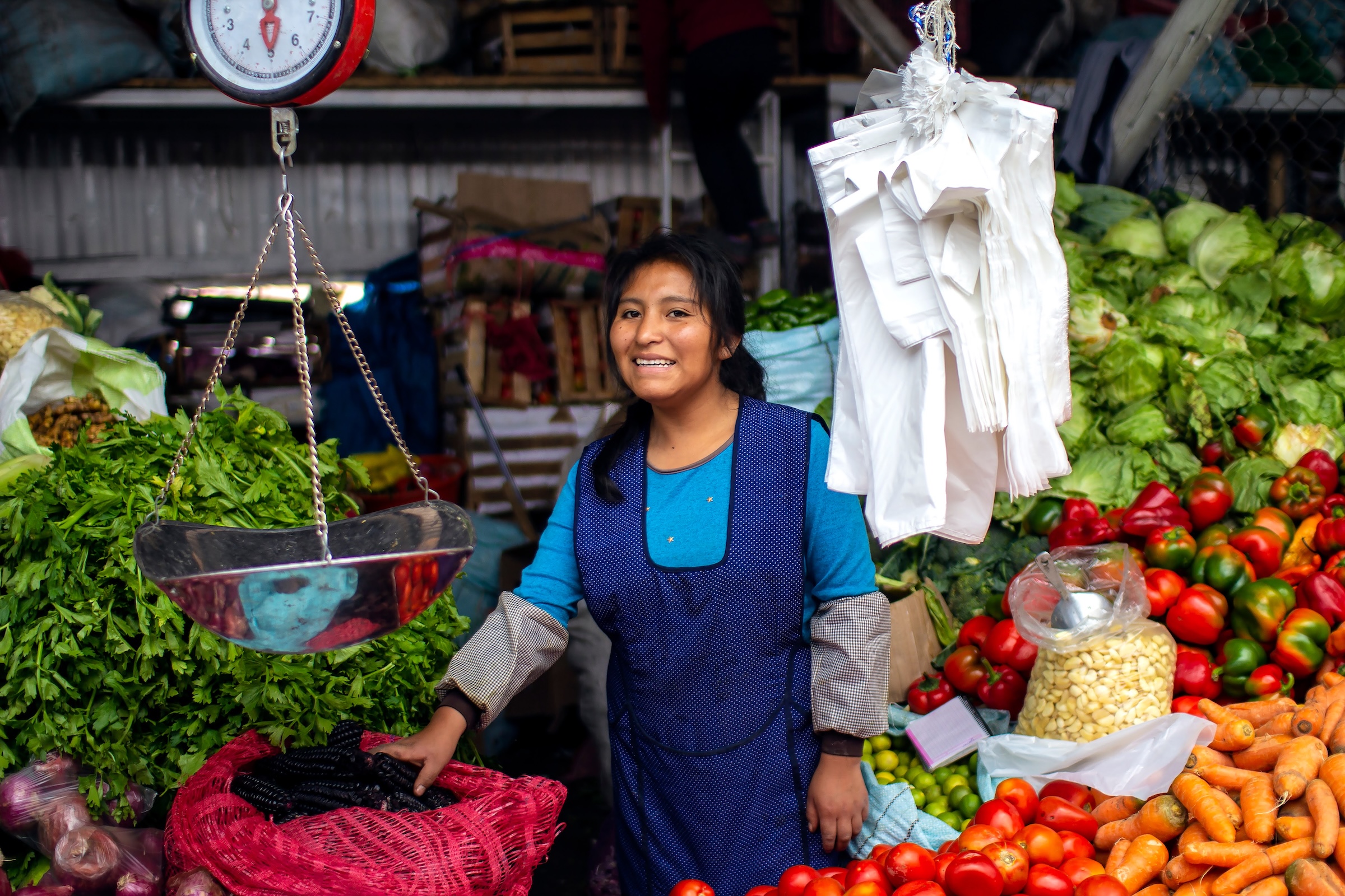 Woman selling fruit and vegetables in a market in Peru