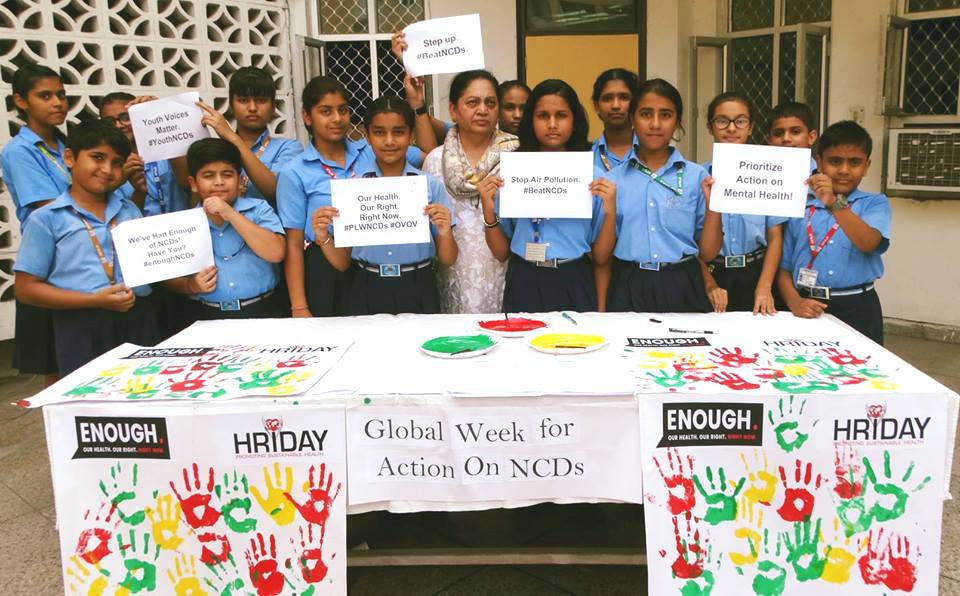 Members of HRIDAY in India, hold up small signs with slogans supporting the Week for Action.