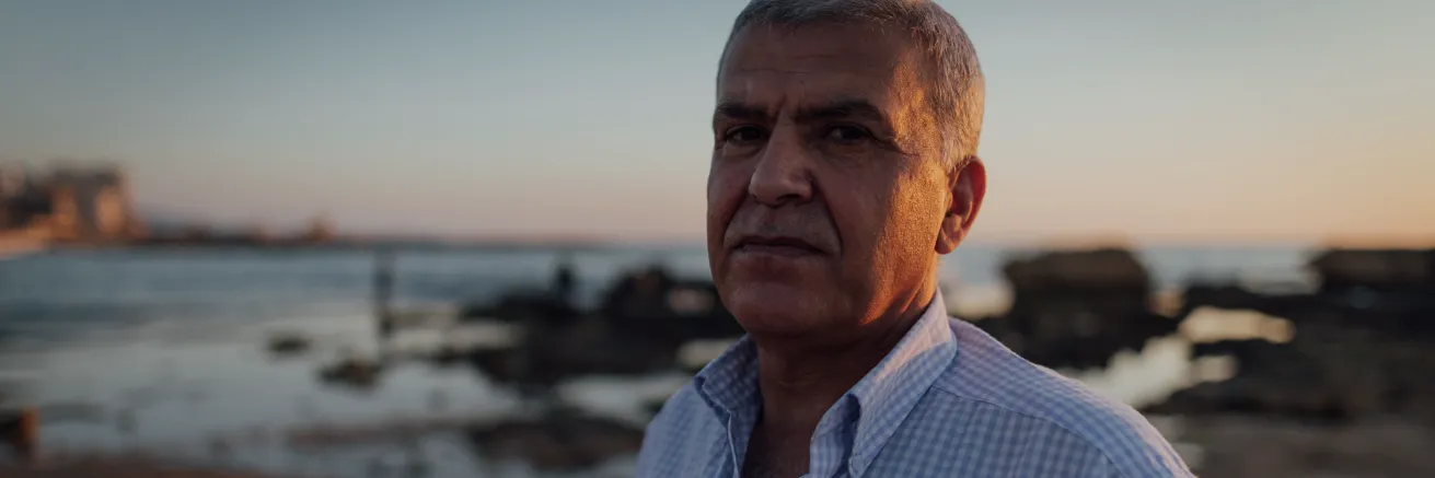 Portrait of man on beach looking at camera during sunset