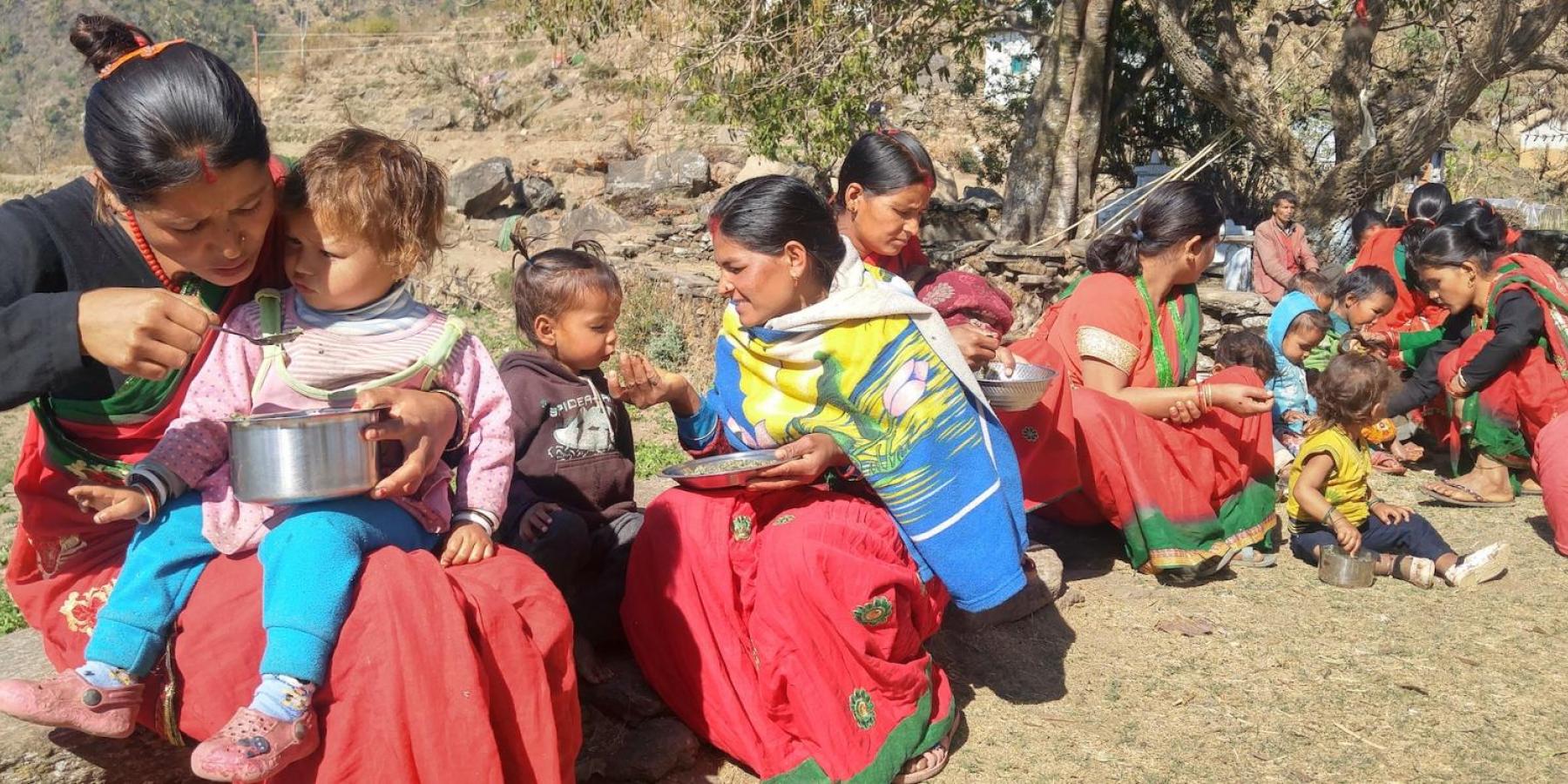 Women feed their children during a weekly mothers' group meeting in a village in Achham District, western Nepal, February 2018.