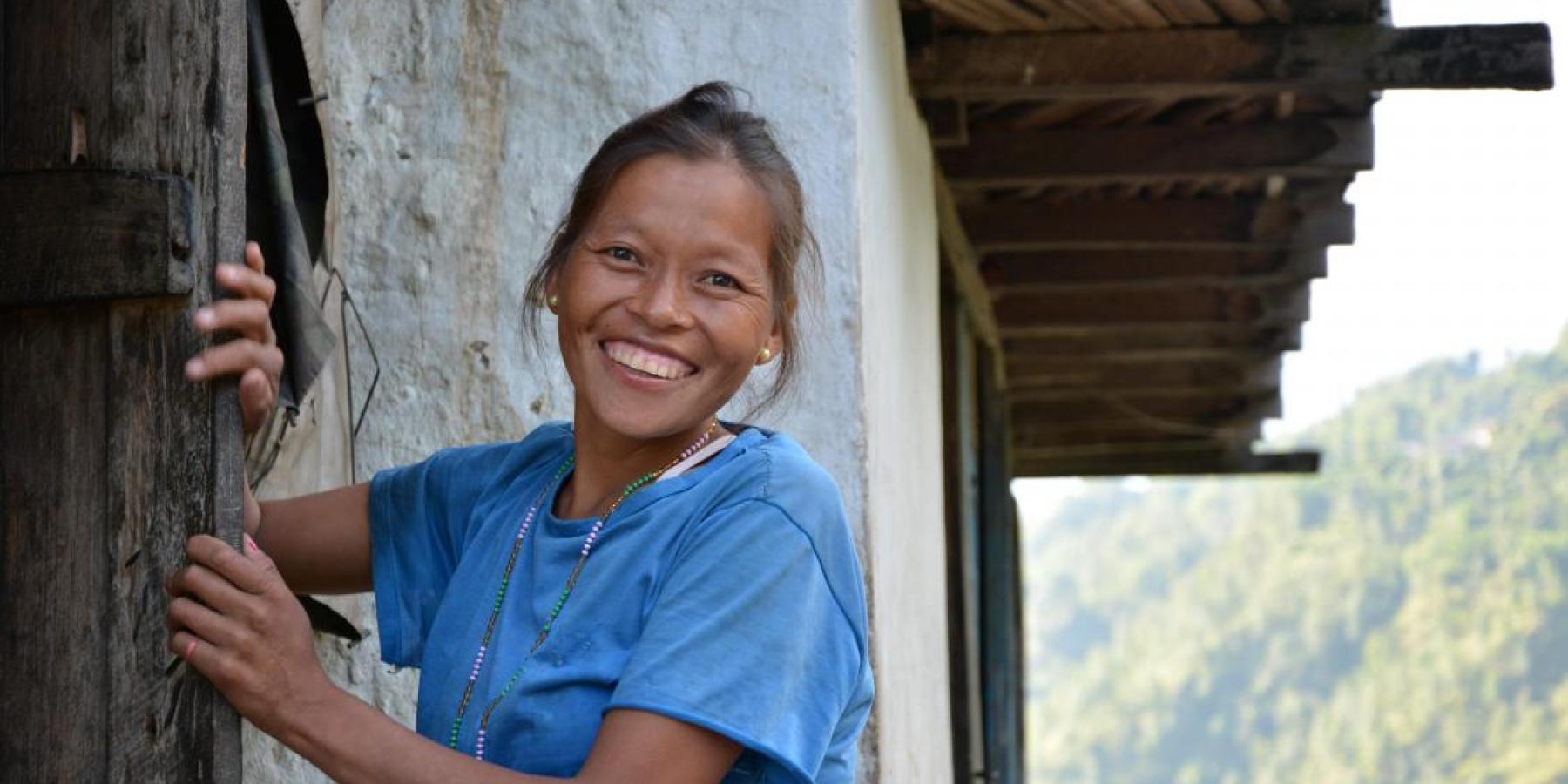 A smiling mother outside her home in Nepal.