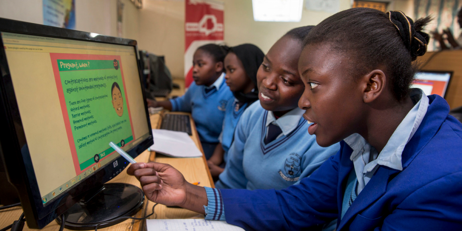 girls in Africa looking at a computer