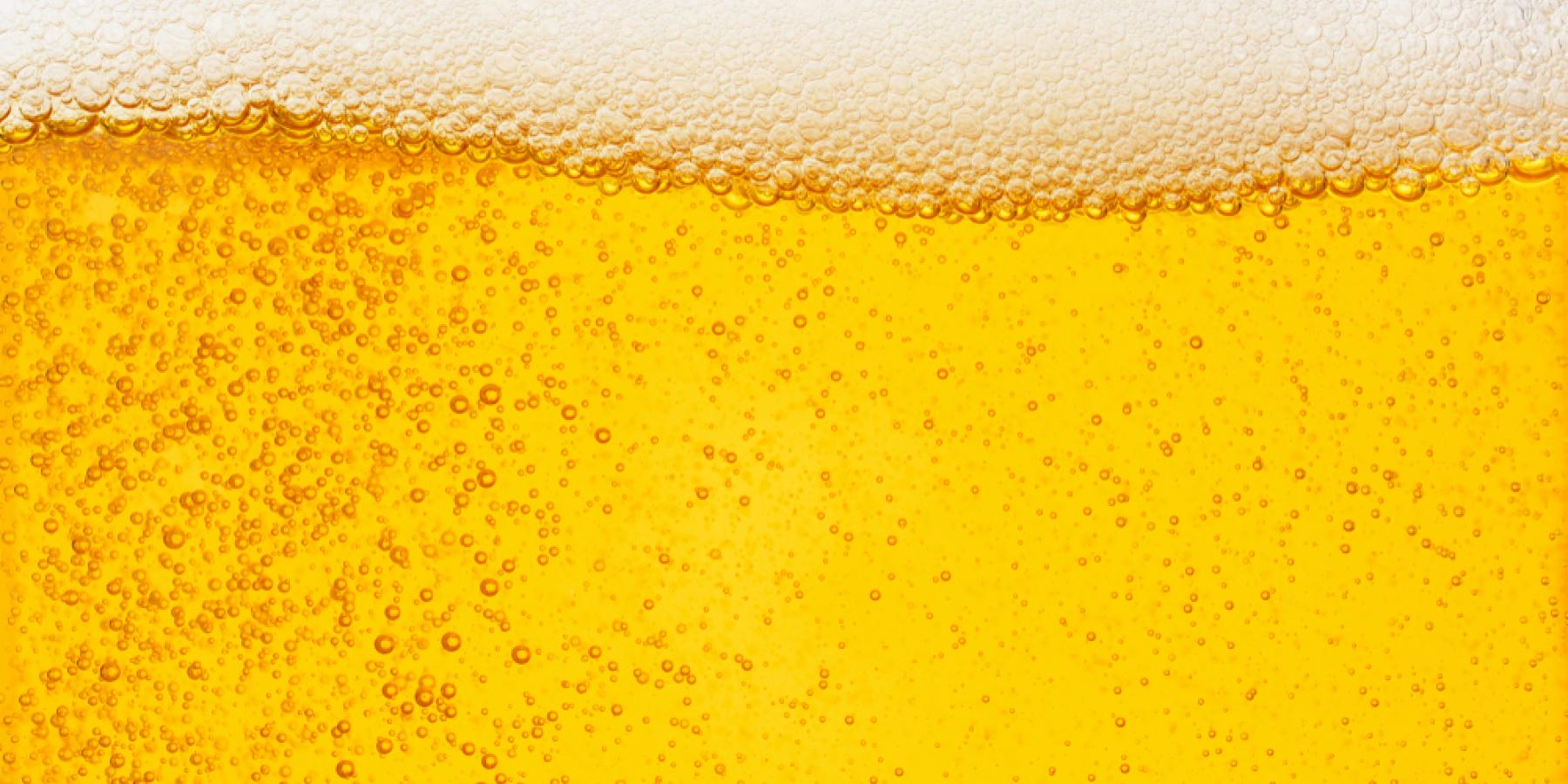 Close-up of a glass of beer showing the head and effervescence