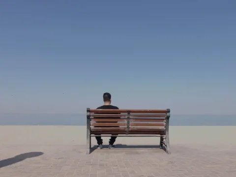 Ali Abbas Muhammed, person living with compulsive obsessive disorder in Kuwait, sitting on a bench alone, still from ´Speaking out against stigma' from the Facing Forward series 