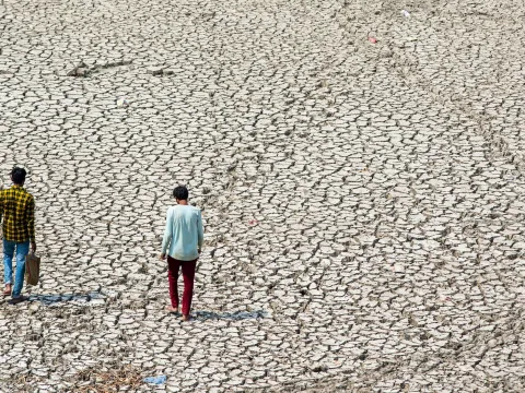 Two people walking in desertified land in New Delhi