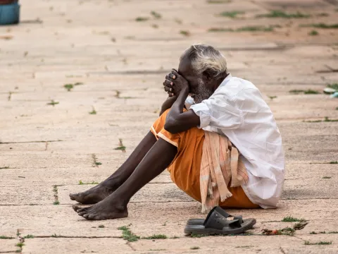 Homeless man sitting alone on the street in India 