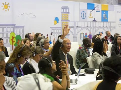 Man raising his hand at an NCD Alliance conference on NCDs