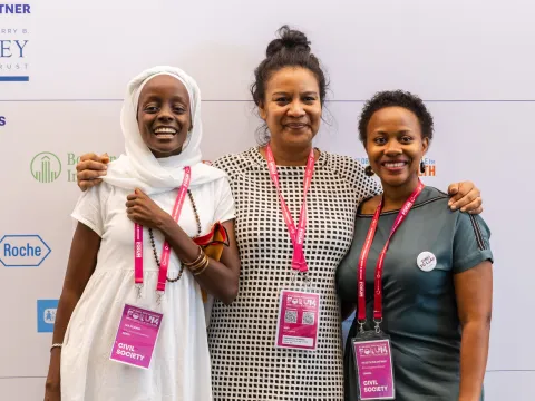Civil society delegates of Global NCD Alliance Forum smiling at the camera with their lanyards