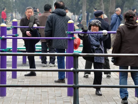 Old people exercising at an outdoor workout park in China 