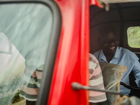 Man in Malawi on the back of a tuk tuk