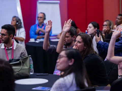 People with hands up at Global NCD Alliance Forum in Kigali 2025