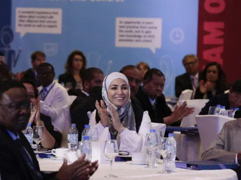 woman clapping in head scarf at ncd alliance forum in sharjah