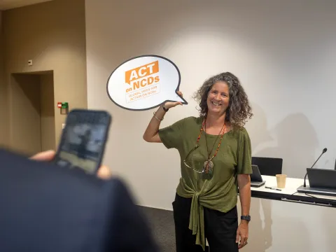 Brazillian woman carrying moment for caring about NCDs sign