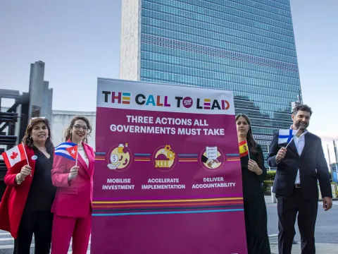 NCDA staff Jimena Marquez, Gina Sanchez and James Bramble with NCDs advocate Lucia Feito holding a Call to Lead banner in New York