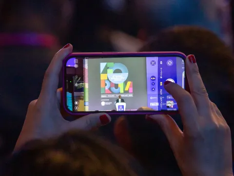 a photo of someone taking a photo of a speaker at global forum in kigali