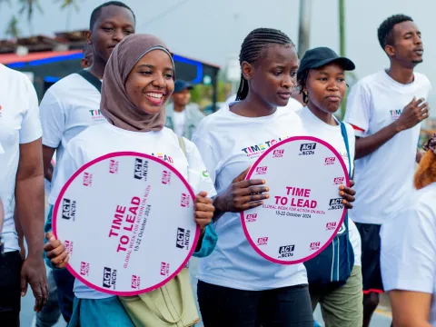 Tanzanian advocates with time to lead on ncds signs smiling during a walk