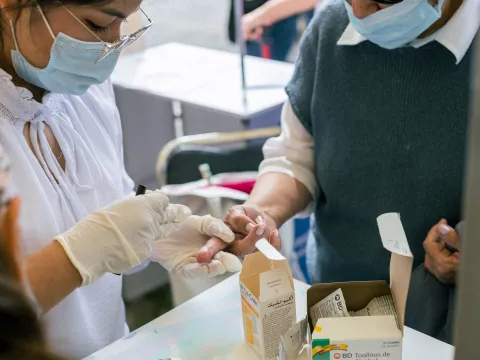 Health worker conducts a finger-prick blood test for diabetes screening at a community outreach clinic in Puebla, Mexico