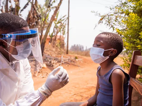 A doctor explaining to a boy how he will do a Covid testing