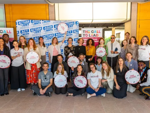 NCD Advocates gather for a picture holding "Time to Lead" banners