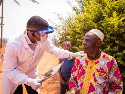 A doctor in Africa visits an elderly patient at their home