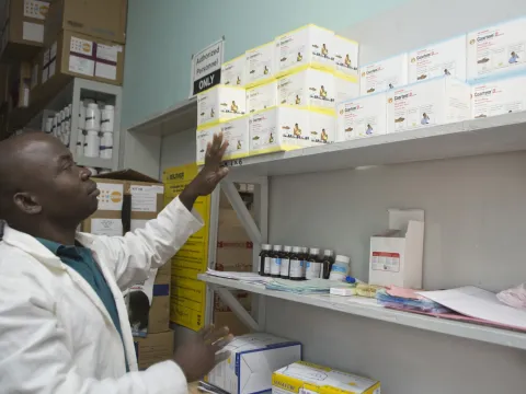 A pharmacist examines available medicines in Malawi.