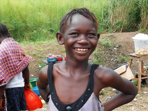 A girl smiles among vendors at a roadside Ebola check point in Port Loko Sierra Leone. 