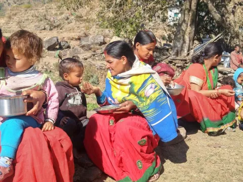 Women feed their children during a weekly mothers' group meeting in a village in Achham District, western Nepal, February 2018.