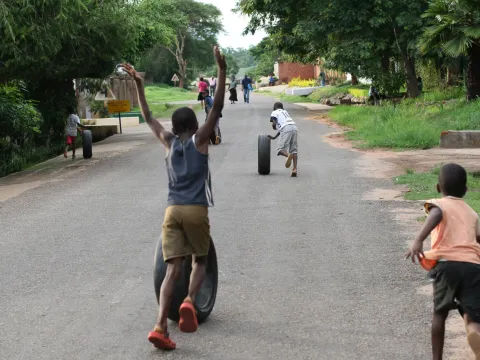 Children roll tires on a street in the Area 14 neighborhood of Lilongwe, Malawi