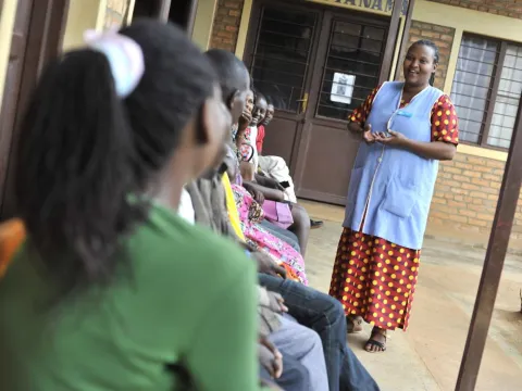 A health worker speaks to clients waiting for services at a clinic in Rwanda