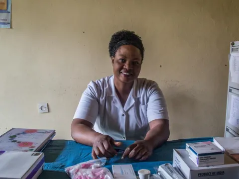 Nurse smiling and sitting at her desk