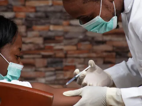 A doctor providing a covid shot in an African setting 