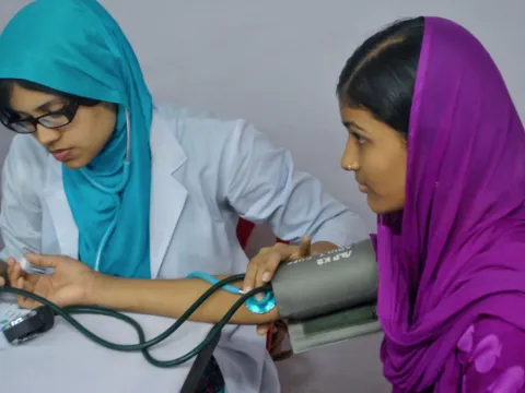A nurse in Pakistan taking blood pressure for a child
