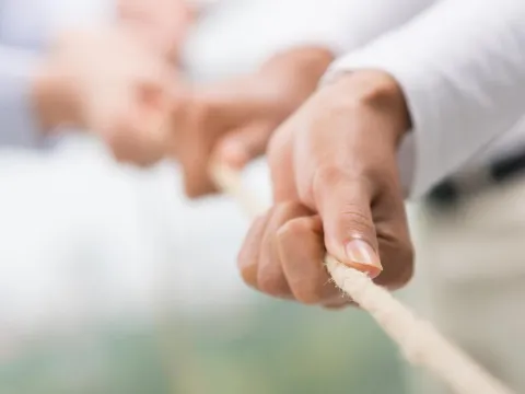 Close up of hands pulling a rope