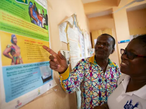 African man pointing at a chart in doctors office with a woman