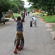 Children roll tires on a street in the Area 14 neighborhood of Lilongwe, Malawi