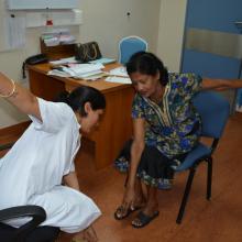 © Photoshare: A Diabetic Specialist Nurse in Port Louis, Mauritius, teaches a patient simple limb exercises.