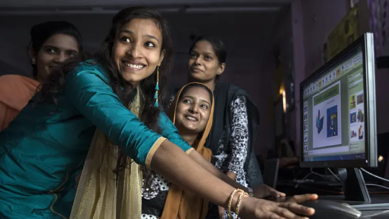 Girls in India in front of e-learning platform on computer smiling