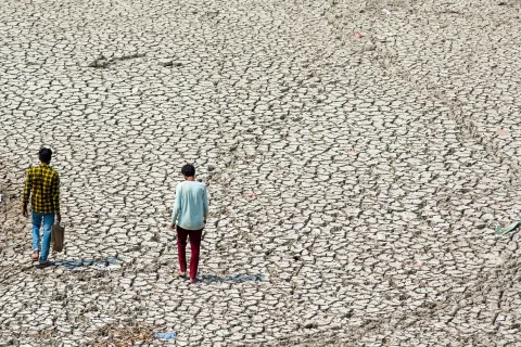 Two people walking in desertified land in New Delhi