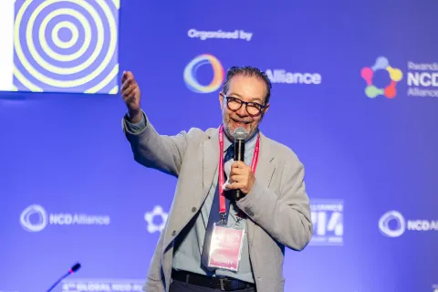 Mexican man Jaime Barba on stage lifting hand at Global NCD Alliance Forum 