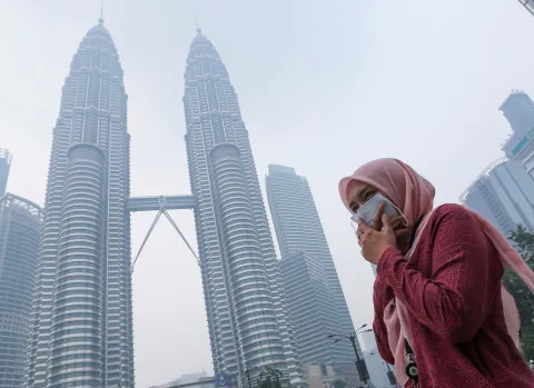 woman wearing mask covers her mouth to protect herself from air pollution in Kuala Lumpur