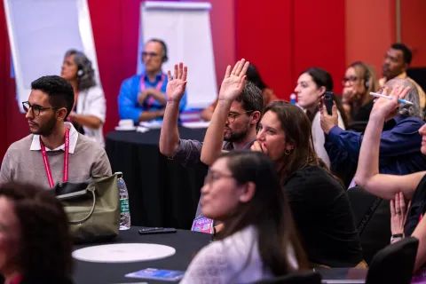 Participants raising their hands at a satellite session at the Global NCD Alliance Forum 2025