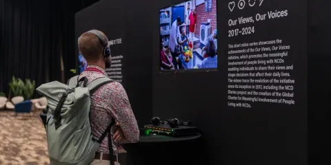 A delegate checks out the interactive exhibition of the Our Views, Our Voices initiative in the Community Zone at the Global NCDA Forum 2025