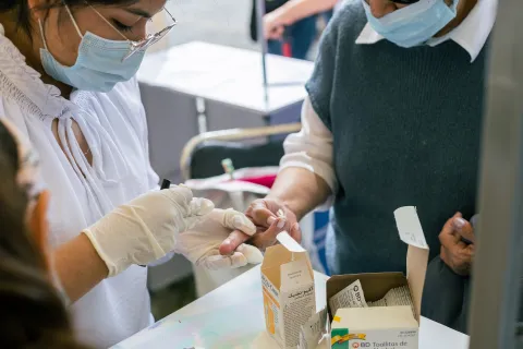 Health worker conducts a finger-prick blood test for diabetes screening at a community outreach clinic in Puebla, Mexico