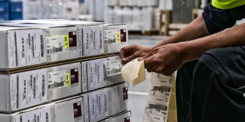 Person sticking labels on boxes to be shipped
