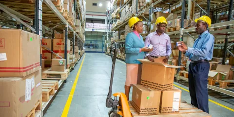 Workers receiving a shipment in a warehouse.