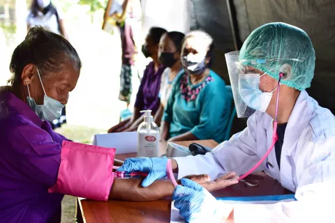 Doctor examining sick patient in face mask