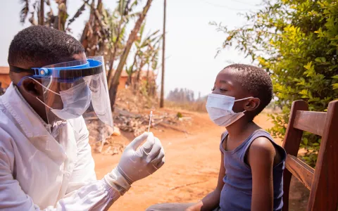 A doctor explaining to a boy how he will do a Covid testing