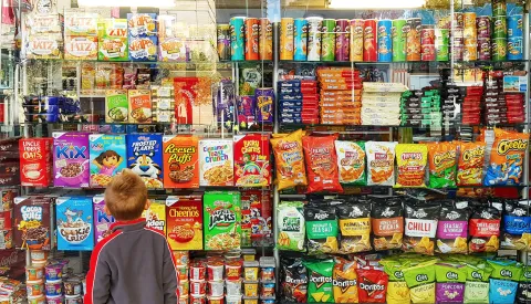 Little boy looking at ultra processed cereal products 