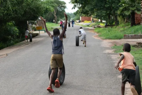 Children roll tires on a street in the Area 14 neighborhood of Lilongwe, Malawi
