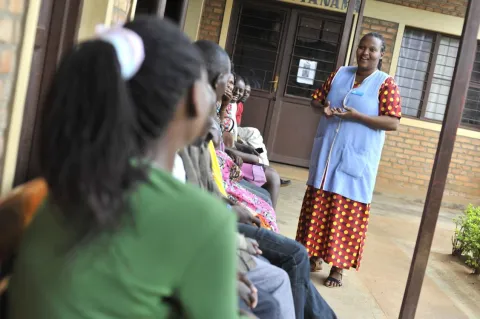 A health worker speaks to clients waiting for services at a clinic in Rwanda
